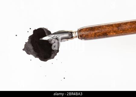 Blick von oben auf die braunen nib Stift über schwarze Tinte Fleck auf weissem Papier Stockfoto