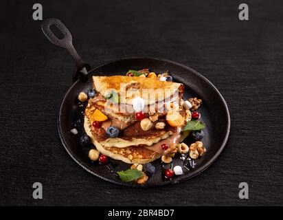 Pfannkuchen mit Beeren und Schokolade Soße des Kochens pan Stockfoto