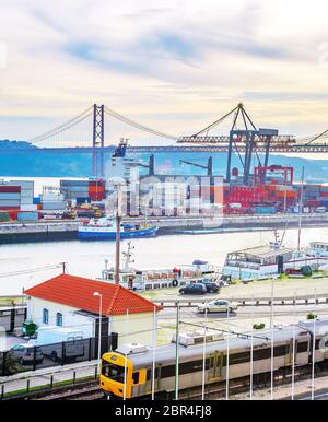 Sonnenuntergang Himmel über Lissabon Handels-, Hafen, Brücke des 25. April, Container auf Pier mit Fracht Krane, Stadt Zug von Lissabon, Portugal Stockfoto