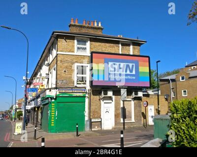 London, Großbritannien - 20. April 2020: Leichtes Display mit SHN (Stay Home Now, Play on Words NHS) mit Regenbogenhintergrund in der Lewisham Street Stockfoto