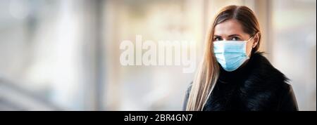 Junge Frau trägt Einweg-blauen Virus Gesicht Mund Nase Maske, Nahaufnahme Porträt - breites Banner mit Platz für Text links. Coronavirus Covid-19 aus Stockfoto