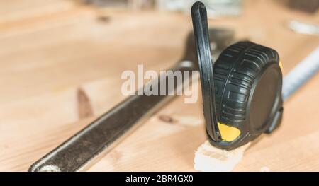 Hammer Nägel Schraubenschlüssel und Meter auf einen Stall in Hellbraun Holz platziert Stockfoto