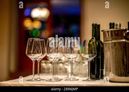 Leere Gläser, Weinflaschen und Eimer mit Eis am Tisch im Restaurant. Eiskübel, Wein Gläser und Flaschen auf dem Tisch arrangiert für Hochzeit Rezept Stockfoto