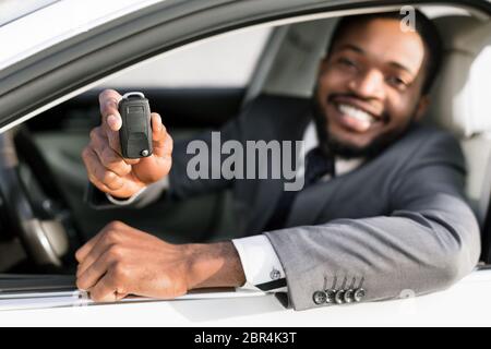 Schwarzer Mann Zeigt Auto-Schlüssel Sitzen In Auto, Flache Tiefe Stockfoto