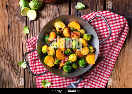 Rosenkohl Kartoffeln Pfanne mit Speck im rustikalen Stil Stockfoto