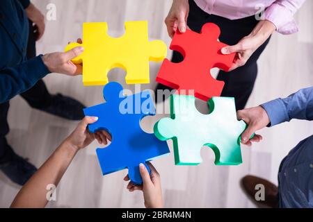 Einen erhöhten Blick auf Hände, die bunten Puzzle Stockfoto