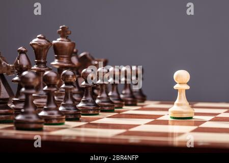 Ein Bauer gegen den vollen Satz Schachfiguren Stücke stehen an Bord Stockfoto