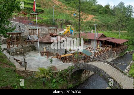 Ein Park mit einer historischen Bogenbrücke und einer Wassermühle in der Stadt iyidere in Rize. Stockfoto