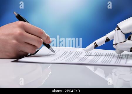 Roboterhand Unterstützung der Person, die für die Abfüllung Form über reflektierende Schreibtisch Stockfoto