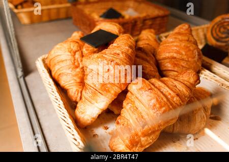 Leckeres, frisch gebackenes Gebäck in einer Konditorei. Viele Brötchen und Croissants auf einem Regal eines Backwarenladens Stockfoto