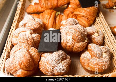 Leckeres, frisch gebackenes Gebäck in einer Konditorei. Viele Brötchen und Croissants auf einem Regal eines Backwarenladens Stockfoto