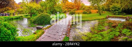 Die verzauberte Eden Garden Brücke über den Teich in horizontaler Panoramablick Nymphe Garten oder Giardino della Ninfa in Latium - Italien. Stockfoto