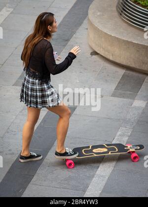 Peking / China - 21. August 2016: Skateboard-Skaterin im modernen Sanlitun-Viertel im Chaoyang-Bezirk im Zentrum von Peking, China Stockfoto