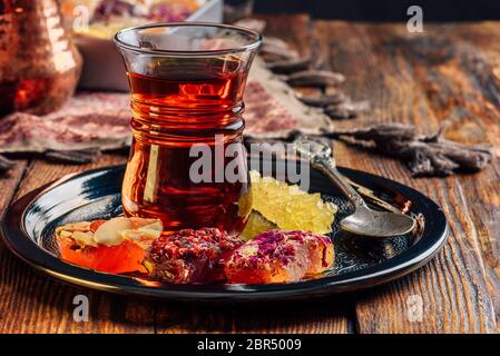Tee in armudu Glas mit Oriental Delight rahat Lokum auf Metall Fach über Holz- oberfläche und Tischdecke Stockfoto