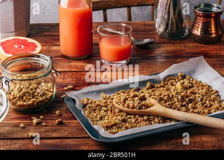 Gebackenes Müsli zum Frühstück mit Saft aus Pampelmusen oder Grapefruits Stockfoto
