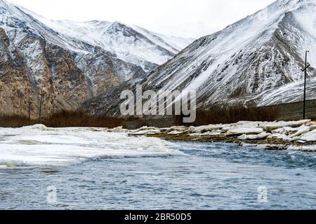 Gefrorener Indus Fluss fließt durch die schneebedeckten Berge von Ladakh, Jammu und Kaschmir, Indien, Asien. Landschaft von natürlicher Schönheit im Nubra Tal. Stockfoto