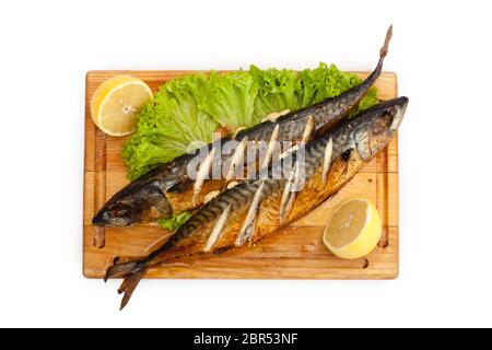 Gebratener Fisch. Makrele auf einem Holzbrett mit Zitrone und Kräutern Stockfoto