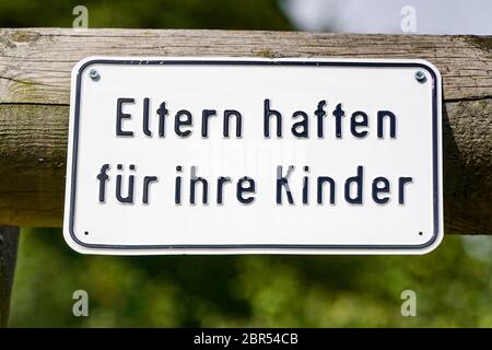 Eltern haften für ihre Kinder in der deutschen Sprache bedeutet - Eltern haften für ihre Kinder anmelden auf einem hölzernen Bar Stockfoto