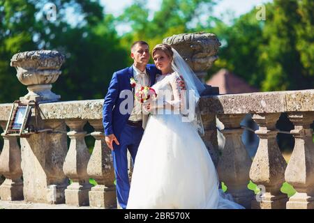 Romantischer Moment. Schöne Braut in einem luxuriösen Brautkleid und stilvolle Braut in einem Smoking Stockfoto