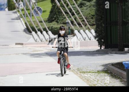 Ankara, Türkei. Mai 2020. Ein Junge mit einer Maske fährt am 20. Mai 2020 in Ankara, Türkei, auf einem Fahrrad. Die türkische Gesundheitsministerin Fahrettin Koca berichtete am Mittwoch über 972 neue COVID-19-Fälle und 23 weitere Todesfälle im Land. Kredit: Mustafa Kaya/Xinhua/Alamy Live News Stockfoto