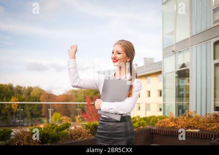 Junge Studentin schreibt ein Tagebuch. Geschäftsfrau mit einer Pfanne in der Hand schreibt in einem Notizbuch Stockfoto