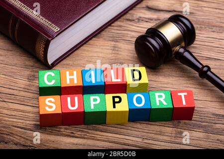 Child Support bunte Block mit Bibel und Hammer über Holz- Schreibtisch im Gerichtssaal Stockfoto