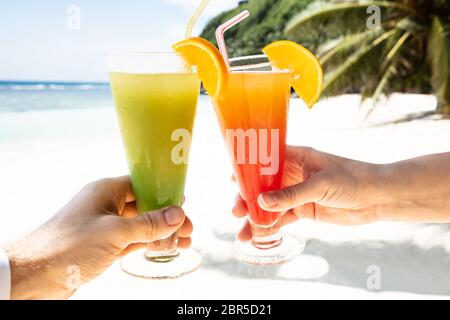 In der Nähe von Paar Hand Toasten der Gläser Cocktail am Strand im Sommer Stockfoto