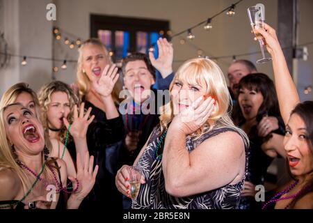 Trans Frau auf einer Party mit begeisterten Freunden Stockfoto