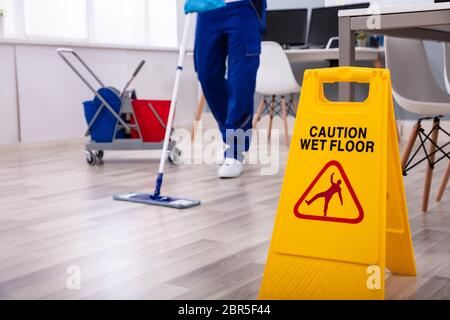 Männliche Hausmeister mit Mop Reinigung modernes Büro Etage Stockfoto