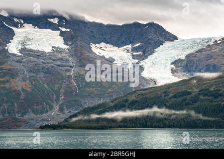 Schmelzwasser stürzt vom Serpentine Glacier in Barry Arm im Harriman Fjord, nahe Whittier, Alaska, auf den Mount Gilbert ab. Der Gletscher hat sich dramatisch von einem Leckerbisse zum hängenden Gletscher zurückgebildet. Stockfoto