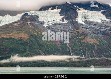 Schmelzwasser stürzt vom Serpentine Glacier in Barry Arm im Harriman Fjord, nahe Whittier, Alaska, auf den Mount Gilbert ab. Der Gletscher hat sich dramatisch von einem Leckerbisse zum hängenden Gletscher zurückgebildet. Stockfoto