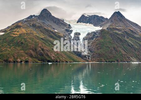 Schmelzwasser stürzt vom Serpentine Glacier in Barry Arm im Harriman Fjord, nahe Whittier, Alaska, auf den Mount Gilbert ab. Der Gletscher hat sich dramatisch von einem Leckerbisse zum hängenden Gletscher zurückgebildet. Stockfoto