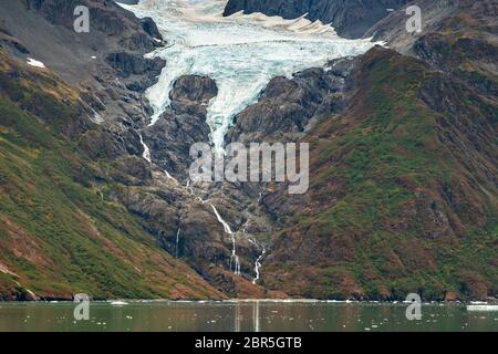 Schmelzwasser stürzt vom Serpentine Glacier in Barry Arm im Harriman Fjord, nahe Whittier, Alaska, auf den Mount Gilbert ab. Der Gletscher hat sich dramatisch von einem Leckerbisse zum hängenden Gletscher zurückgebildet. Stockfoto