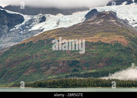 Schmelzwasser stürzt vom Serpentine Glacier in Barry Arm im Harriman Fjord, nahe Whittier, Alaska, auf den Mount Gilbert ab. Der Gletscher hat sich dramatisch von einem Leckerbisse zum hängenden Gletscher zurückgebildet. Stockfoto