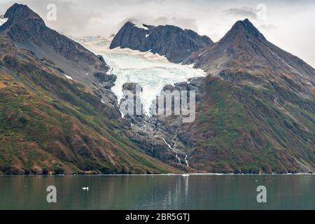 Schmelzwasser stürzt vom Serpentine Glacier in Barry Arm im Harriman Fjord, nahe Whittier, Alaska, auf den Mount Gilbert ab. Der Gletscher hat sich dramatisch von einem Leckerbisse zum hängenden Gletscher zurückgebildet. Stockfoto