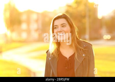 Vorderansicht Portrait Of Happy Teen abgelenkt zu Fuß auf der Straße bei Sonnenuntergang Stockfoto