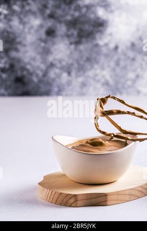 Kochen Dalgona Kaffee mit Schlagschaum . Dalgona Kaffeesahne aus Instant-Kaffee, Zucker und Milch ist in einer Tasse und einem Schneebesen aus einem Mixer. Stockfoto