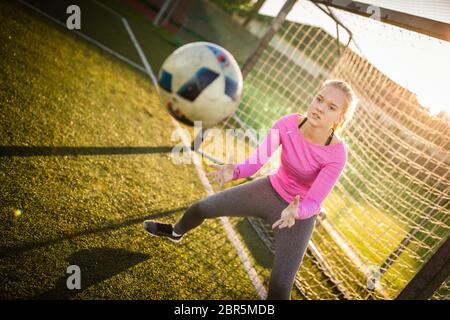 Jugendlich weiblichen goalie fängt einen Schuß während ein Fußball-Spiel Stockfoto