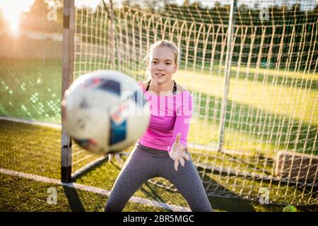 Jugendlich weiblichen goalie fängt einen Schuß während ein Fußball-Spiel Stockfoto