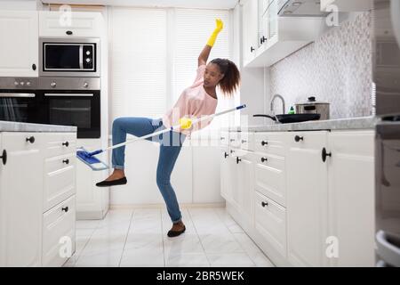 Nahaufnahme einer jungen afrikanischen Frau rutscht beim Wischen in der Küche Stockfoto