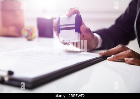 Nahaufnahme der Geschäftsfrau Stempel setzen auf Dokumente im Büro Stockfoto