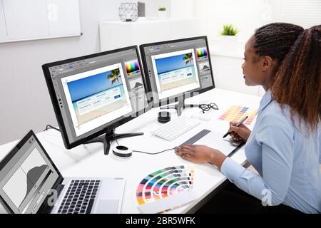 Junge weibliche Designer Bearbeiten von Fotos auf dem Computer im Büro Stockfoto