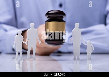 Nahaufnahme eines Richters markante Hammer zwischen Familie Figur über reflektierende Schreibtisch Stockfoto