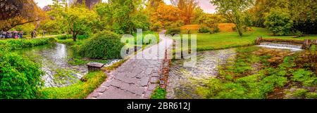 Die verzauberte Eden Garden Brücke über den Teich in horizontaler Panoramablick Nymphe Garten oder Giardino della Ninfa in Latium - Italien. Stockfoto