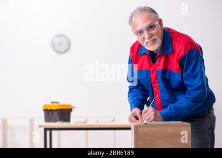 Alte Tischler, die in Innenräumen an Möbeln arbeiten Stockfoto