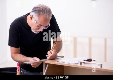 Alte Tischler, die in Innenräumen an Möbeln arbeiten Stockfoto