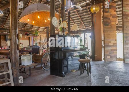 Piano und Requisiten im Land Loft Innenarchitektur Zimmer. Interior Design Zimmer gehören Holz Tisch und Stuhl und Lampe. Interior Design Zimmer in Teil von Livi Stockfoto