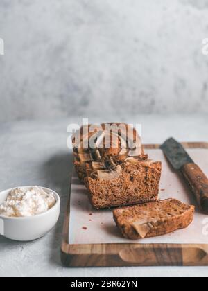 Butter, Zucker-freien Bananenbrot mit Hafermehl, weiche Quark, Honig. Seitenansicht Bananenscheiben Brot auf Holz Schneidebrett. Platz kopieren. Ideen recip Stockfoto