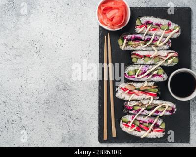 Vegane sushi Sandwich onigirazu mit Pilzen und Gemüse. Gesund essen Rezept und Idee. Bunte japan Sandwich onigirazu mit Rotkraut, Radieschen Stockfoto