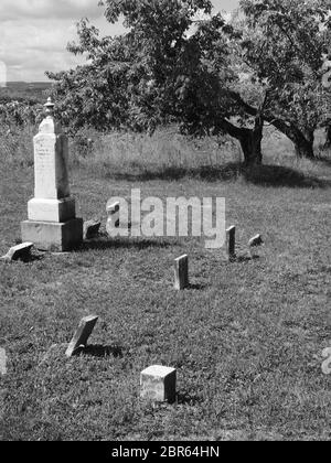 Uralter Friedhof in Schwarz und Weiß aus dem 19. Jahrhundert. Einige Steine sind kurz davor, zu fallen, und zeigen Vernachlässigung und Verschleiß. Stockfoto